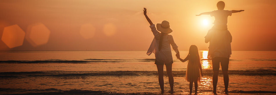 Ferien 2028: Eine Familie erlebt einen Sonnenuntergang am Strand